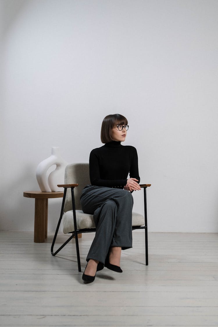 A Woman In Long Sleeves Sitting On Chair