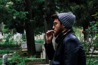 Man Smoking Cigarette Near Green Leaf Tree