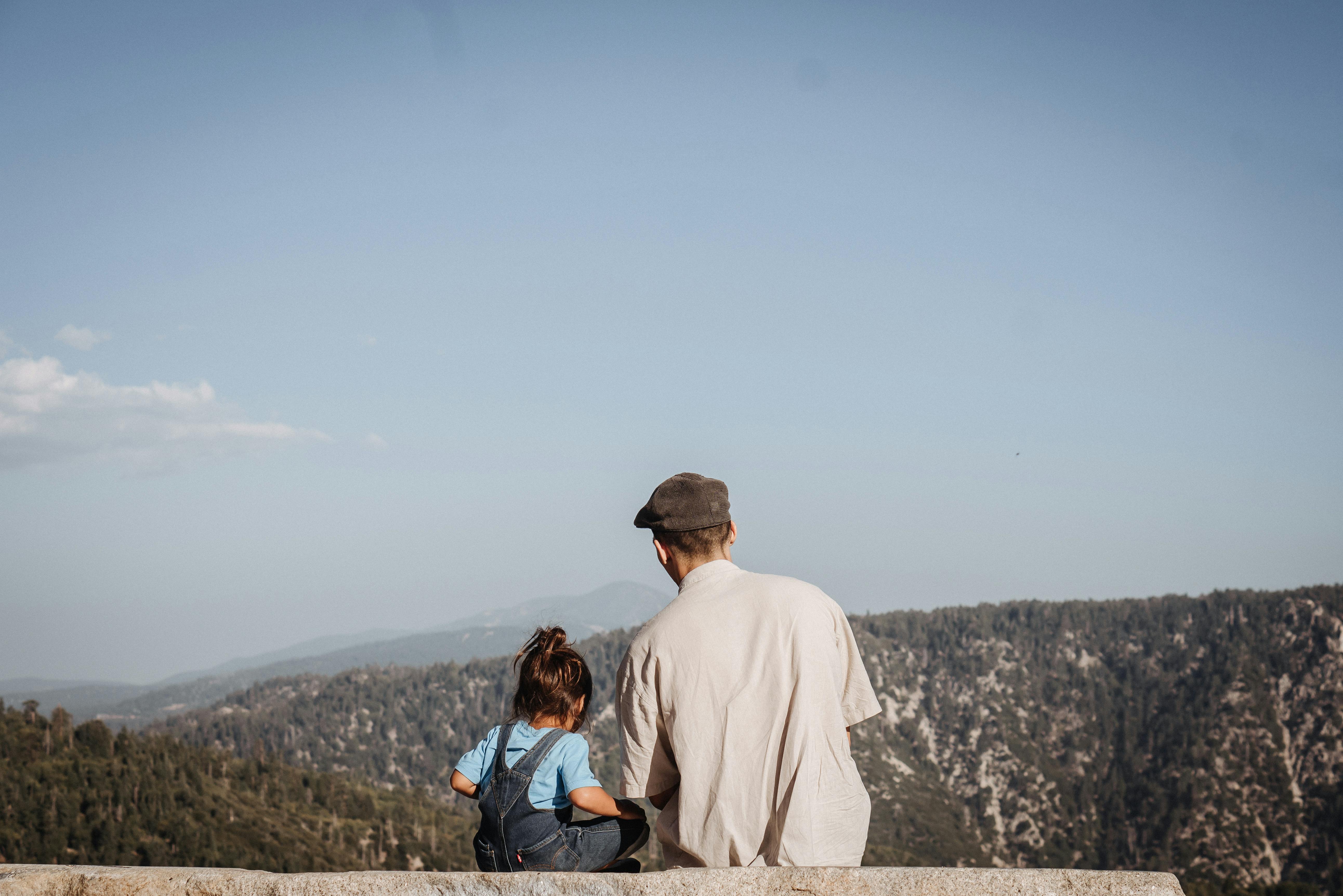 A father and child enjoy a peaceful moment overlooking scenic mountains at Big Bear, California.