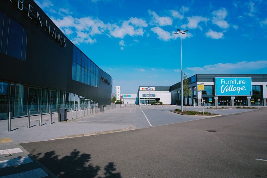Large outdoor retail center with storefronts and a parking area
