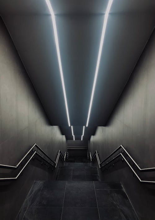 Lighted Gray Concrete Staircase With Stainless Steel Railings