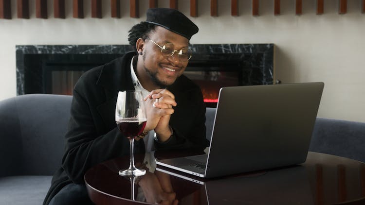 Man In Black Jacket Sitting In Front Of A Laptop Computer