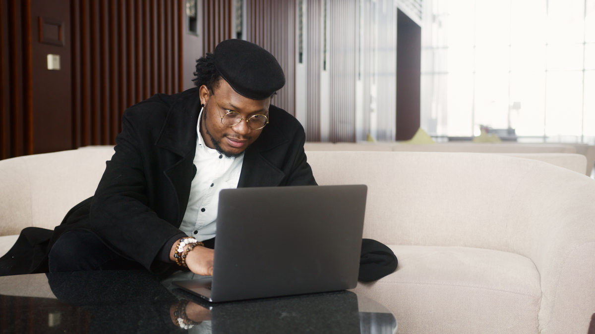 Black technology professional assisting a customer with a laptop