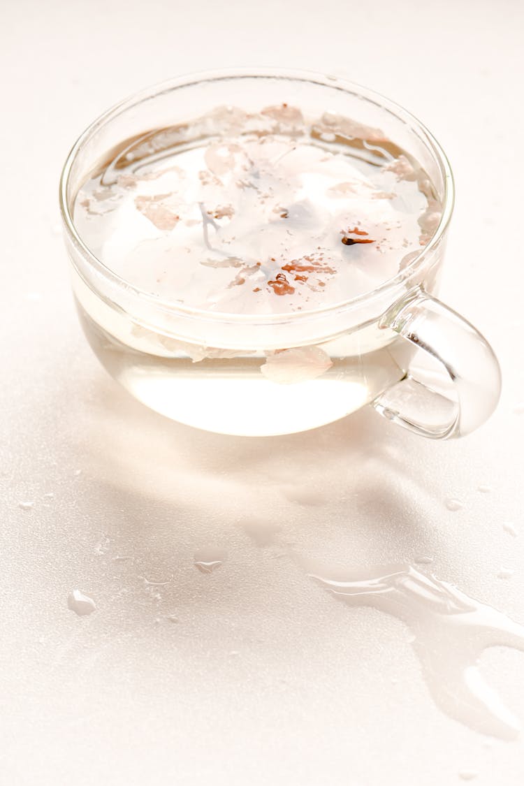 Glass Cup With Water And Cherry Blossoms