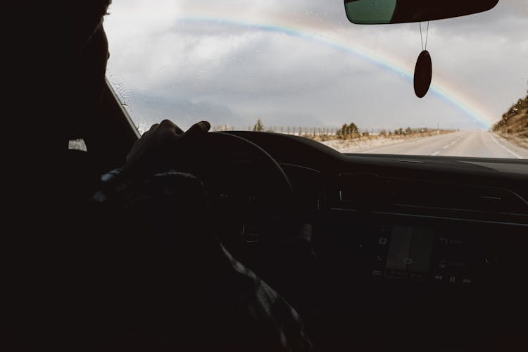 Rainbow Over A Road Visible From Inside Of A Car