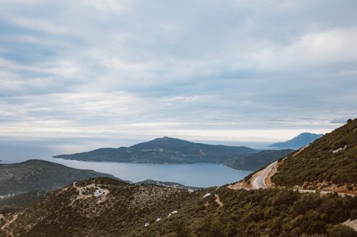 Free A breathtaking aerial capture of a coastal mountain landscape with a serene sea view. Stock Photo