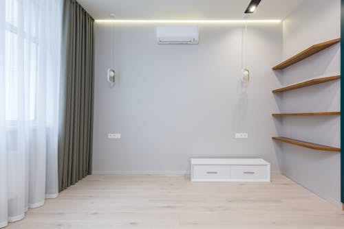 Interior of minimalist room with wooden shelves and AC