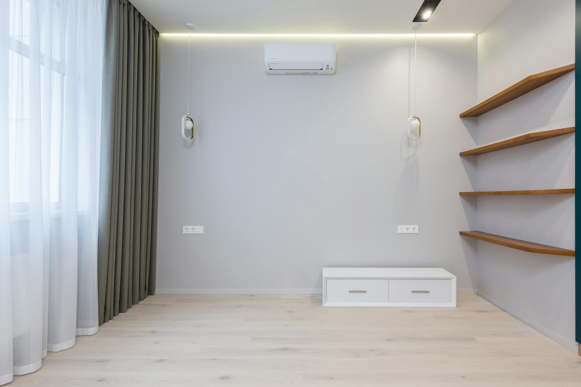 A minimalist room interior with wooden shelves and soft lighting