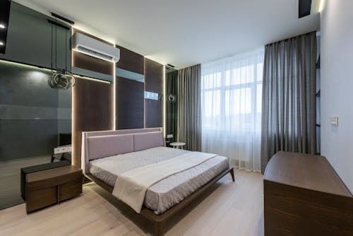 Wooden furniture and bed in contemporary apartment in daylight