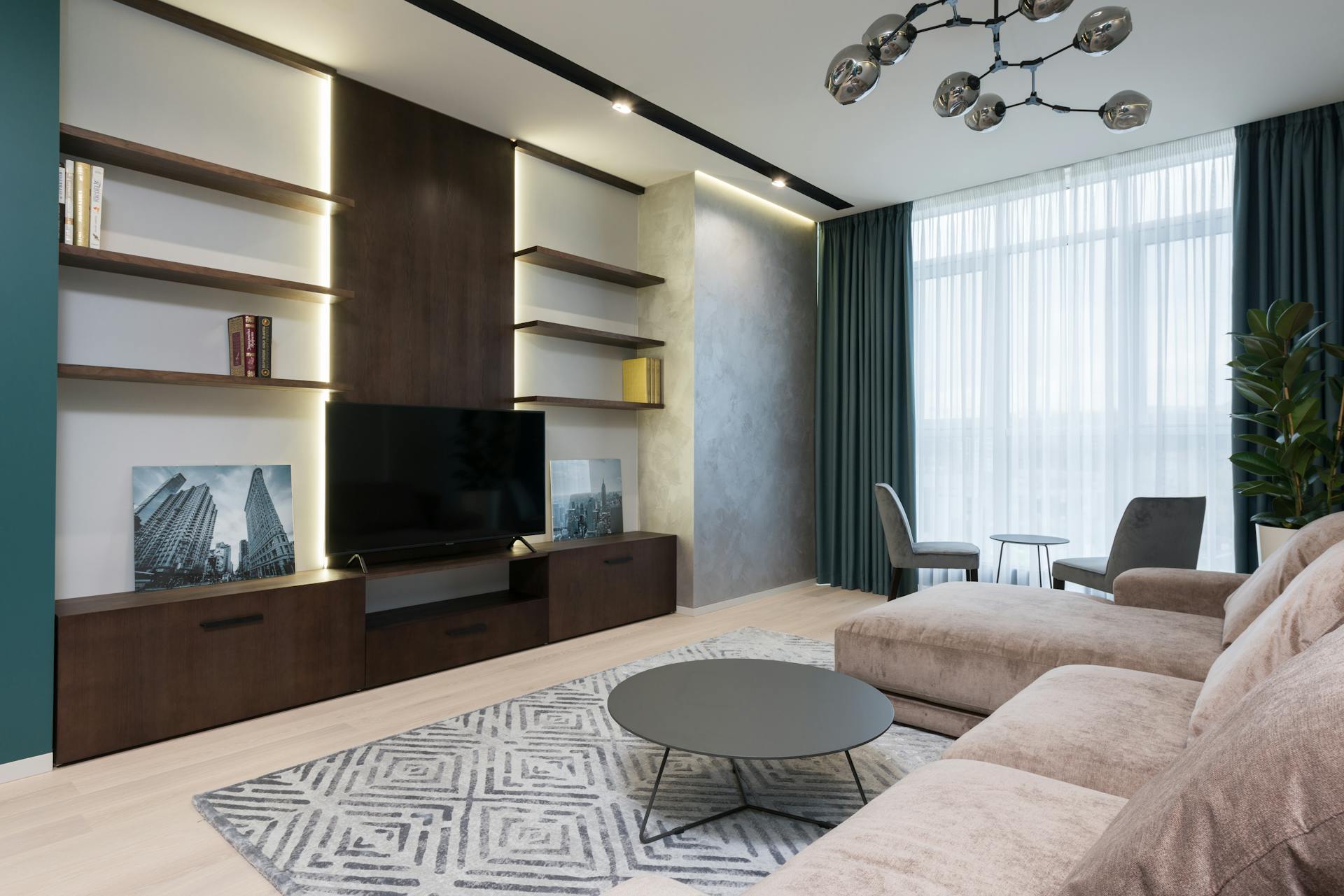 Modern TV set placed on wooden cabinet in front of soft couch in cozy living room