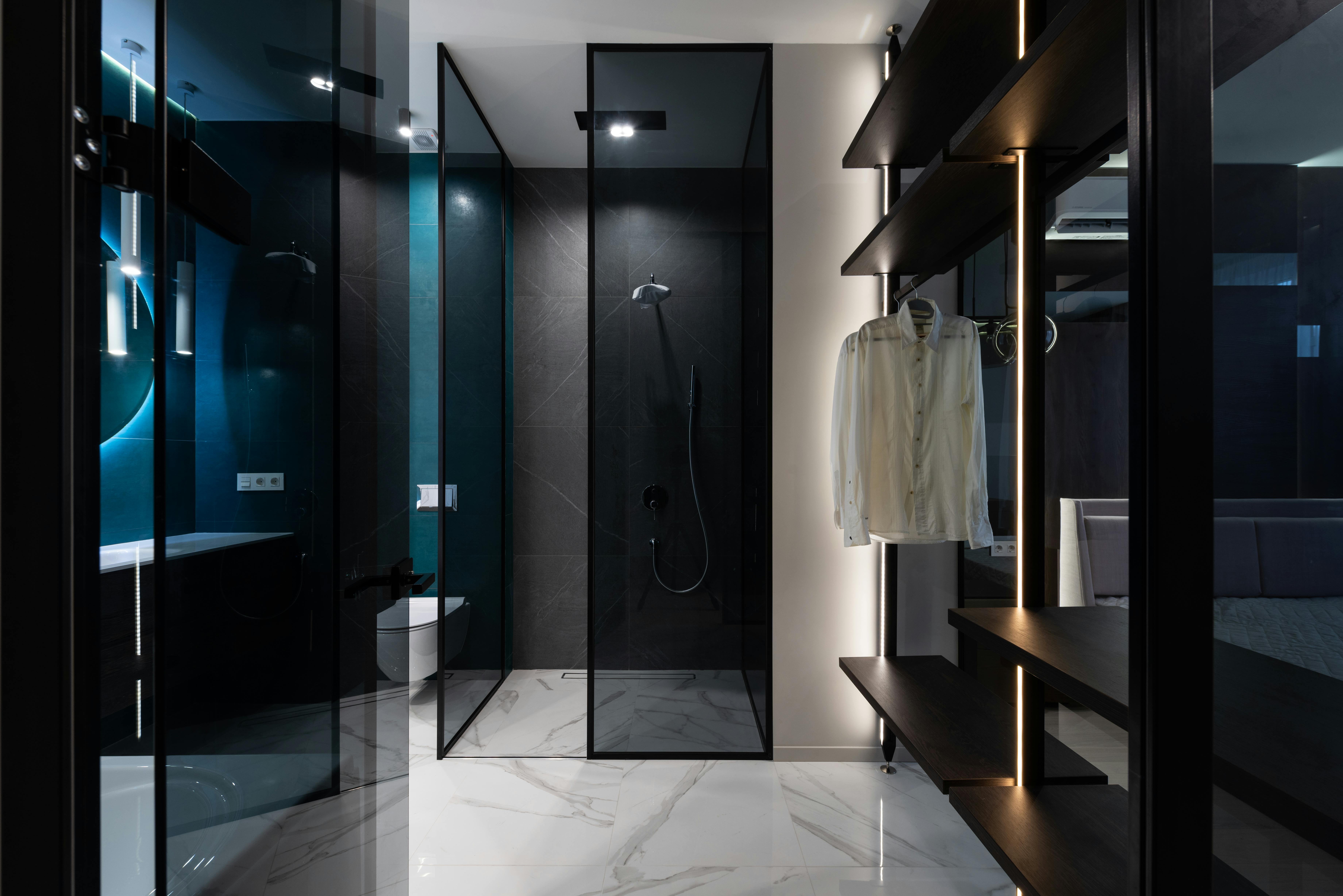 wardrobe and bathroom with glass walls in modern bedroom