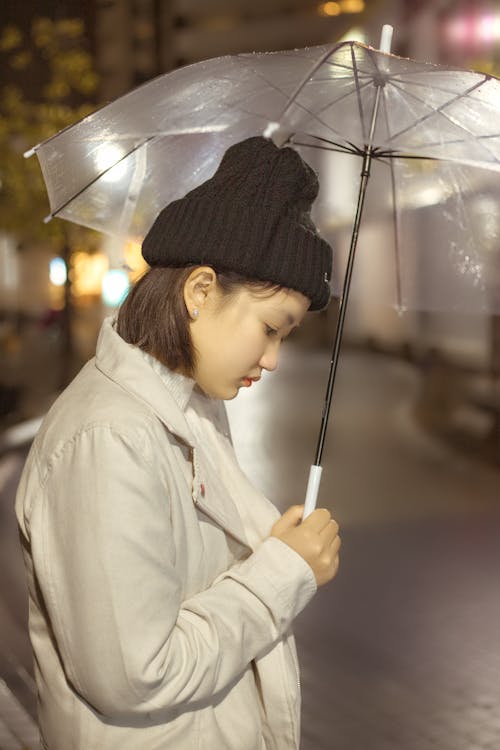 Woman in White Coat Holding Umbrella