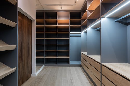 Free Interior of modern spacious wardrobe room with empty shelves near door and mirror Stock Photo