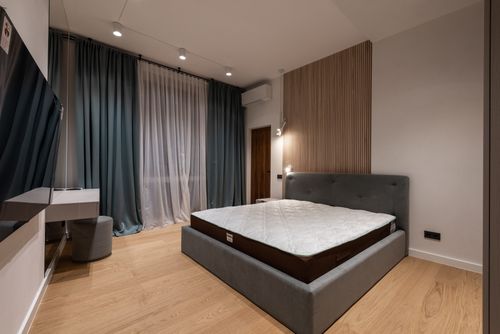 Free Modern TV set and comfy bed in stylish room decorated with lamps and curtains Stock Photo
