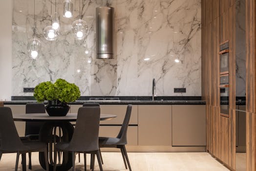 A luxurious modern kitchen featuring a marble backsplash and stylish furniture.