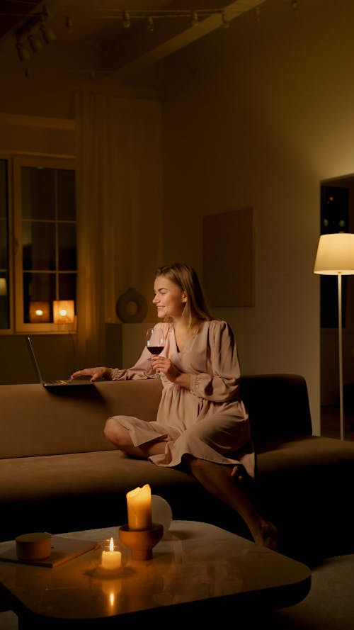 Woman in Pink Dress Using Her Laptop