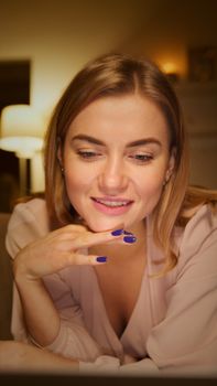 Portrait of a smiling woman relaxing indoors with a warm ambiance. Perfect for lifestyle and relaxation themes.