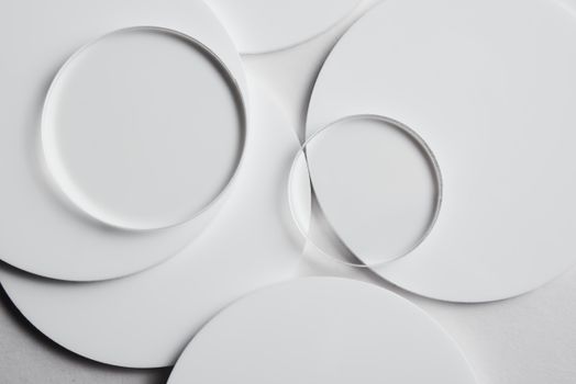 Geometric composition of clear glass and white discs on a plain surface.