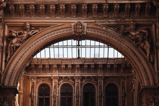 A beautifully intricate arch featuring detailed sculptures and rich ornamentation in a classical style.