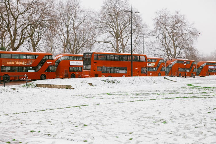 Red Double Decker Buses Near Snow-Covered Ground