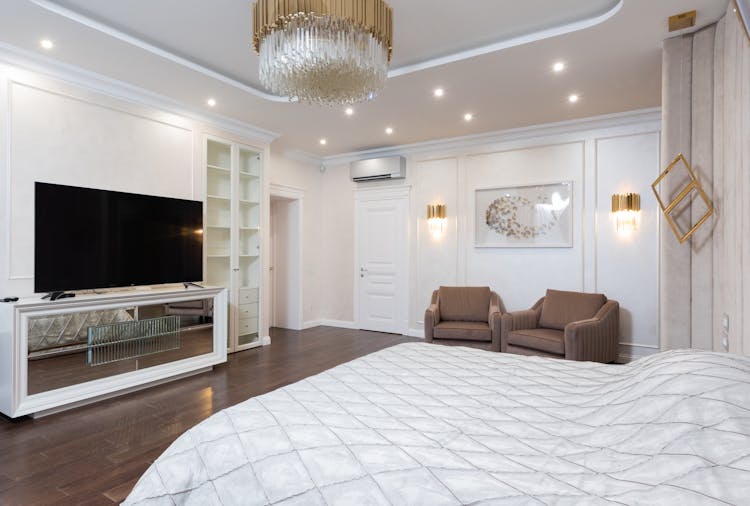 Interior Of Spacious Classic Styled Bedroom Decorated With Golden Chandelier And Lamps