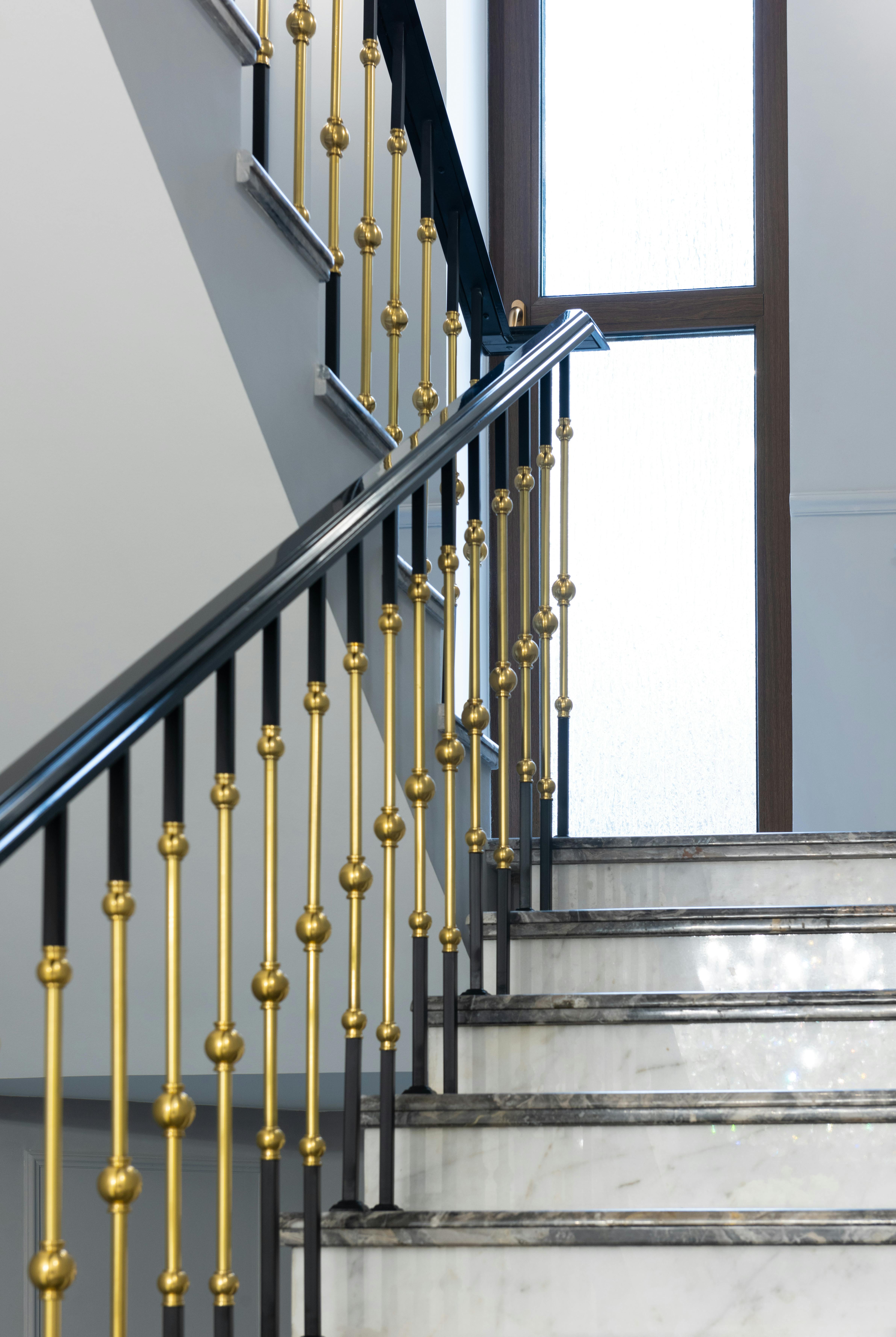 staircase with marble steps and metal banister in house
