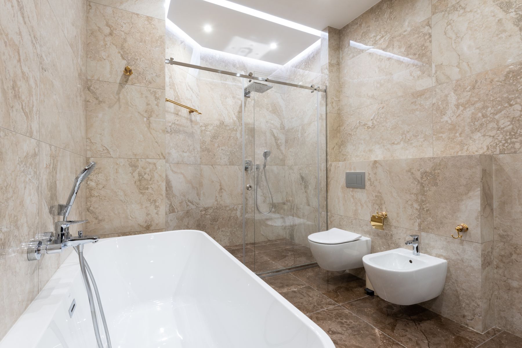 Marble bathroom with freestanding bathtub and glass walk-in shower
