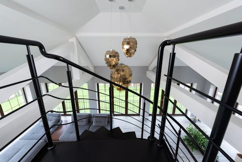 Modern black stairs leading to lounge with soft sofas