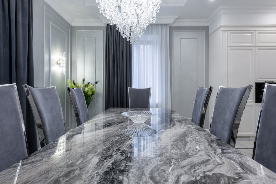 Interior of contemporary dining room with stylish marble table and comfortable chairs in light apartment in daytime