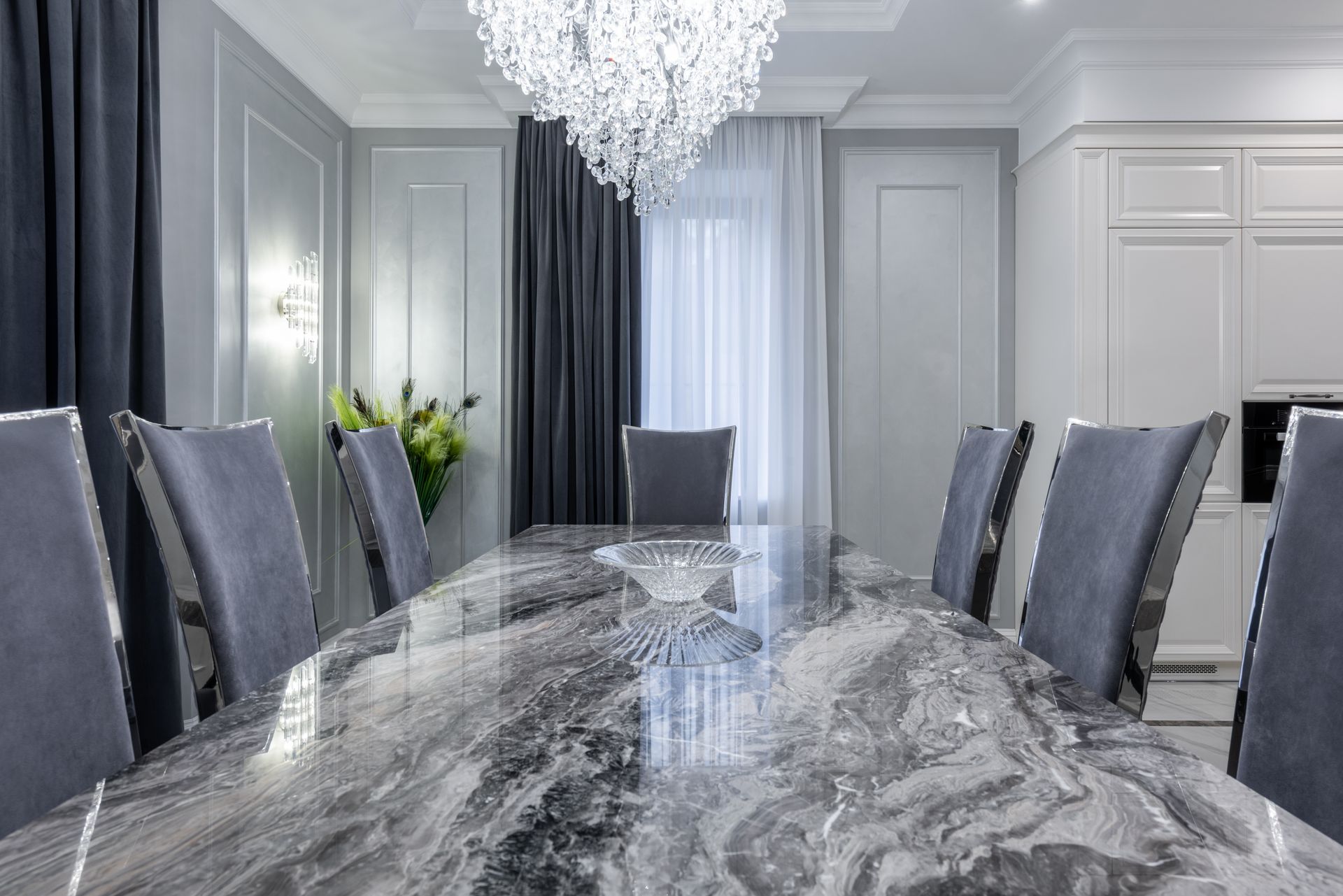 Interior of contemporary dining room with stylish marble table and comfortable chairs in light apartment in daytime