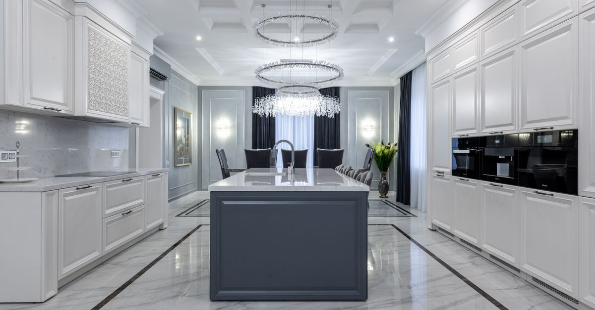 Interior of contemporary spacious kitchen with light expensive furniture placed in apartment with minimalistic design