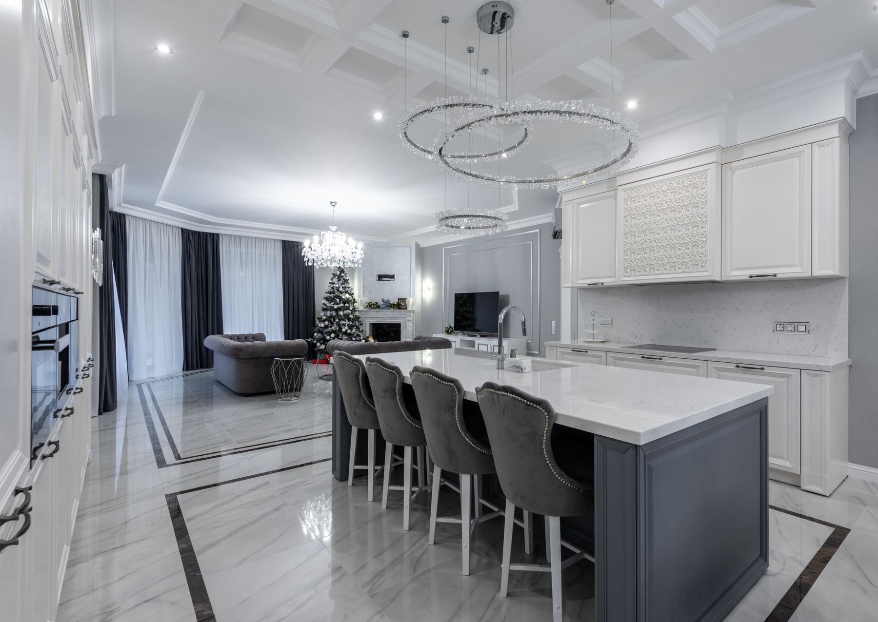 Spacious open kitchen with clear counters and a Christmas tree in the adjacent living area