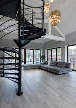 Bright modern living room with spiral staircase and elegant decor.