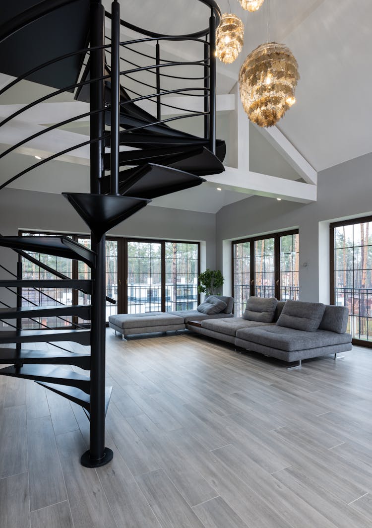 House Interior With Spiral Staircase Near Couch And Windows