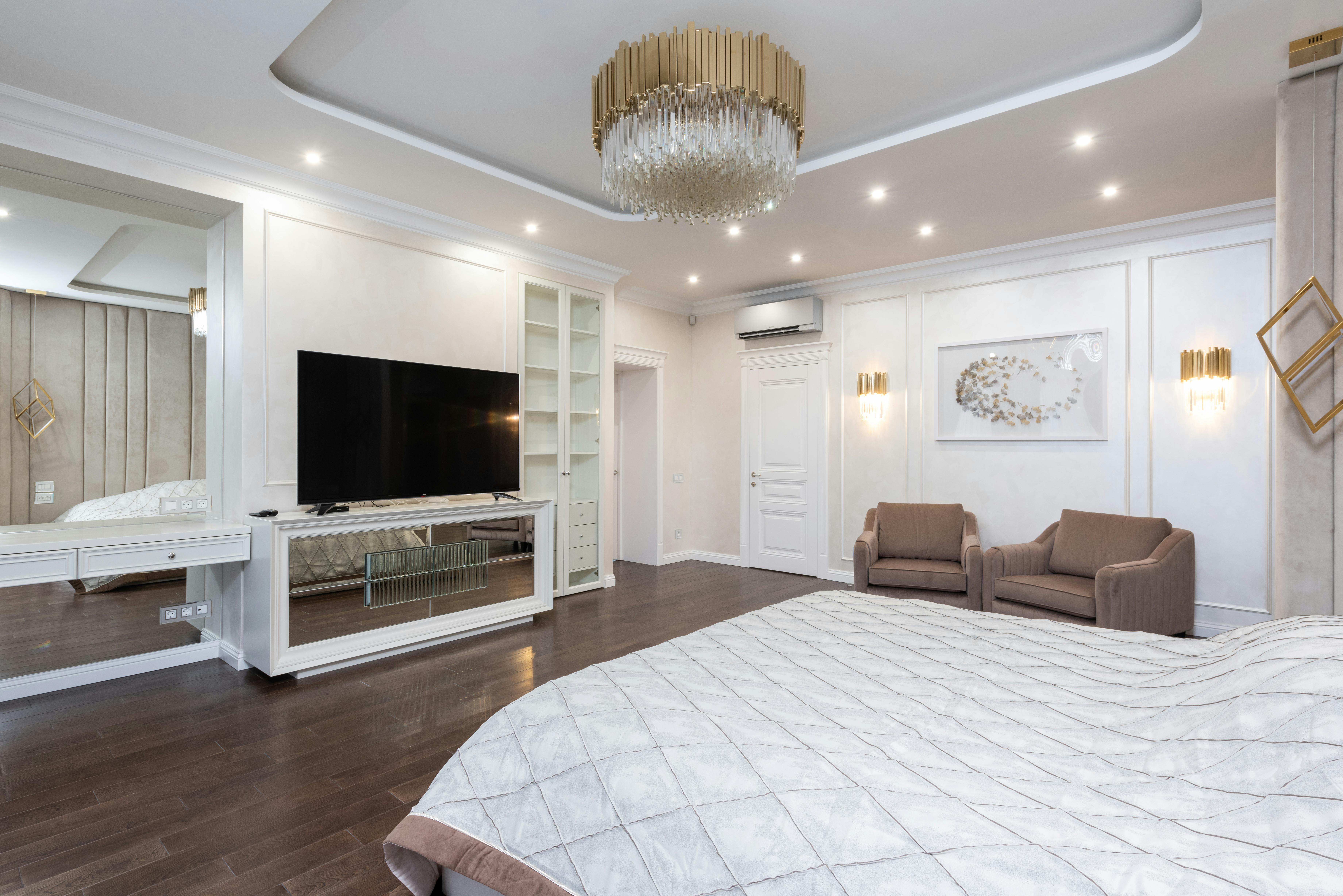 classic bedroom with armchairs and tv next to bed