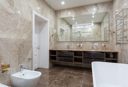 Spacious modern bathroom with marble walls, large mirror, bidet, and elegant fixtures.