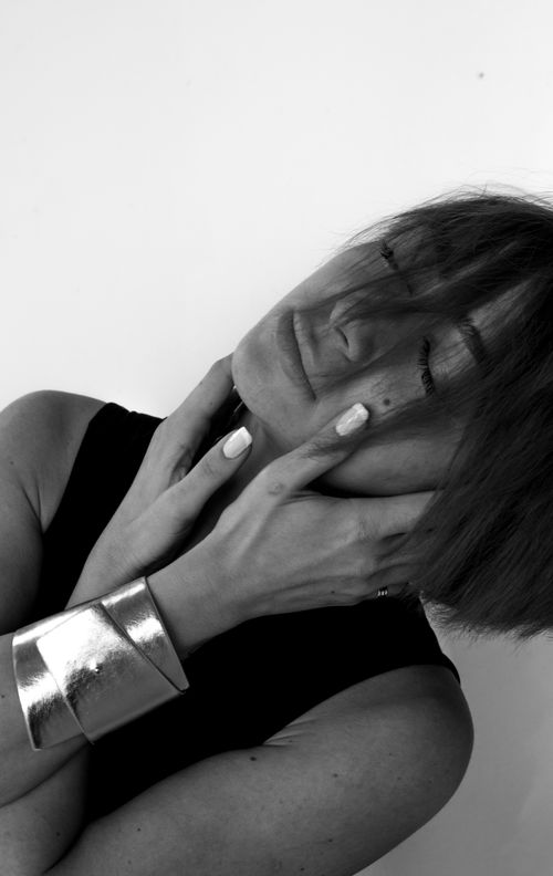 Free Stylish monochrome portrait of a woman with short hair and silver jewelry in a graceful pose. Stock Photo