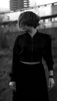 Stylish woman in a city setting captured in a moody black and white photo.