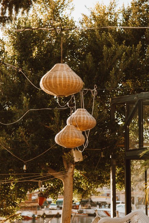 Free Charming straw lanterns hanging outdoors in a lush garden, evoking a traditional ambiance. Stock Photo