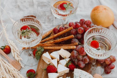 Free A sophisticated cheese board with wine and fruits, perfect for a classy picnic. Stock Photo