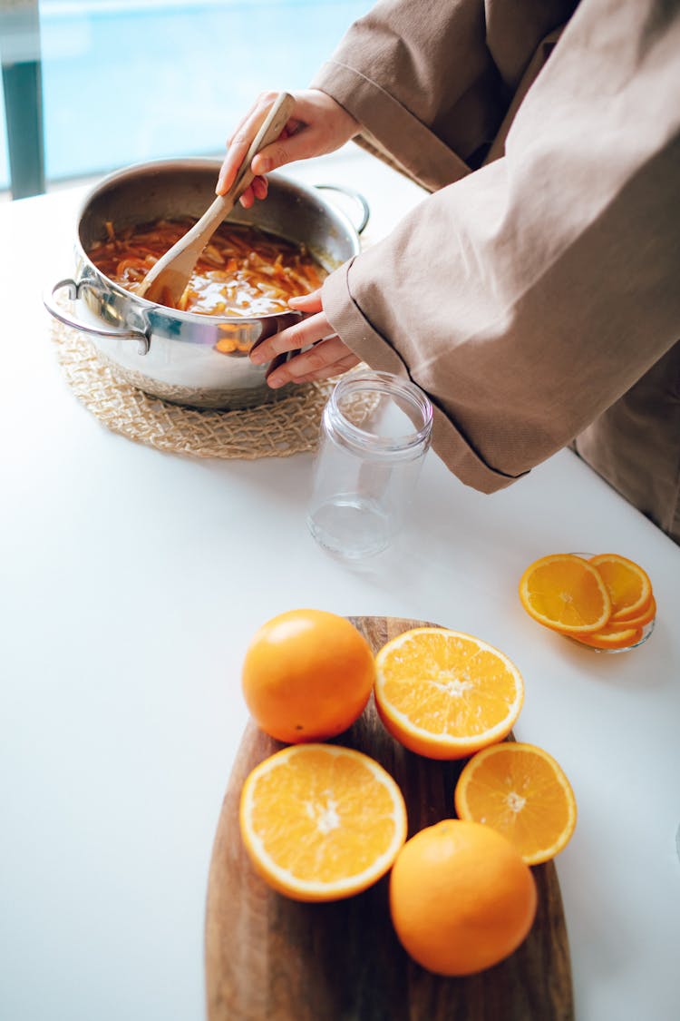 Hands Mixing Food In Pot With Kitchen Spoon