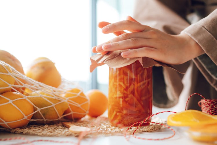 Woman Packing Jar With Orange Jam