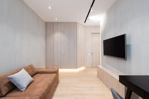 House interior with couch in front of TV on wall