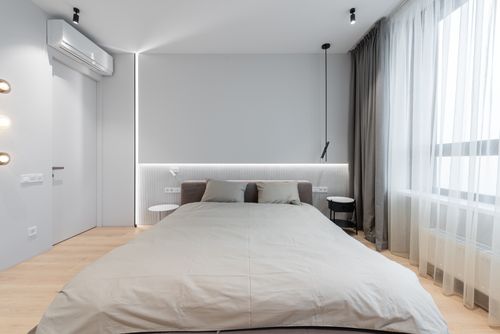 Free Interior of modern bedroom with bed next to table with curtains on windows Stock Photo