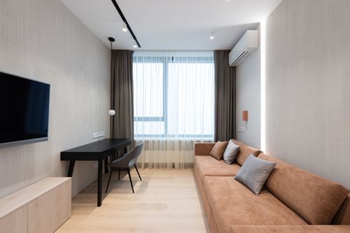 Free Interior of modern apartment with sofa with pillow in front of TV on wall next to table with chair and window with curtains Stock Photo