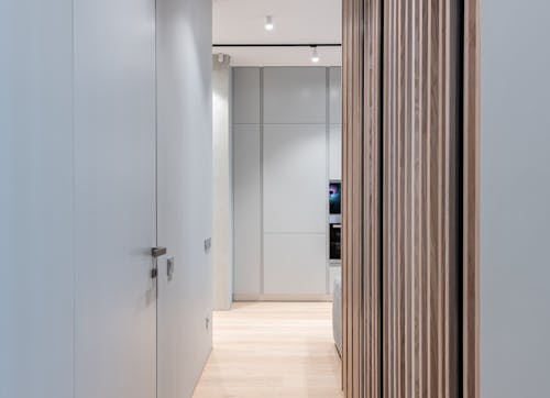 Modern empty hallway interior with door and walls leading to light spacious room