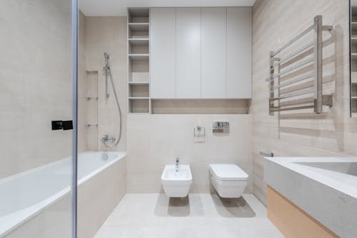 Free Interior of modern light bathroom with toilet and bidet next to bathtub and sink Stock Photo