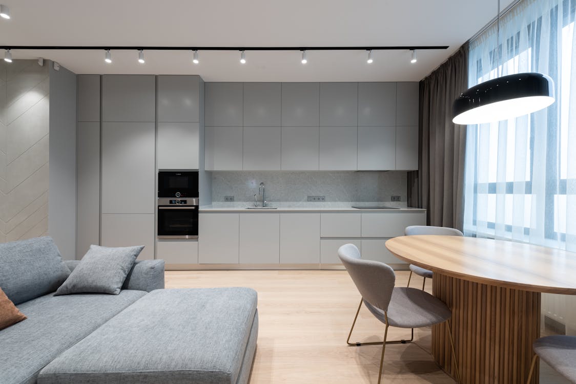 Interior of modern residential apartment with comfortable furniture and compact kitchen in grey shades