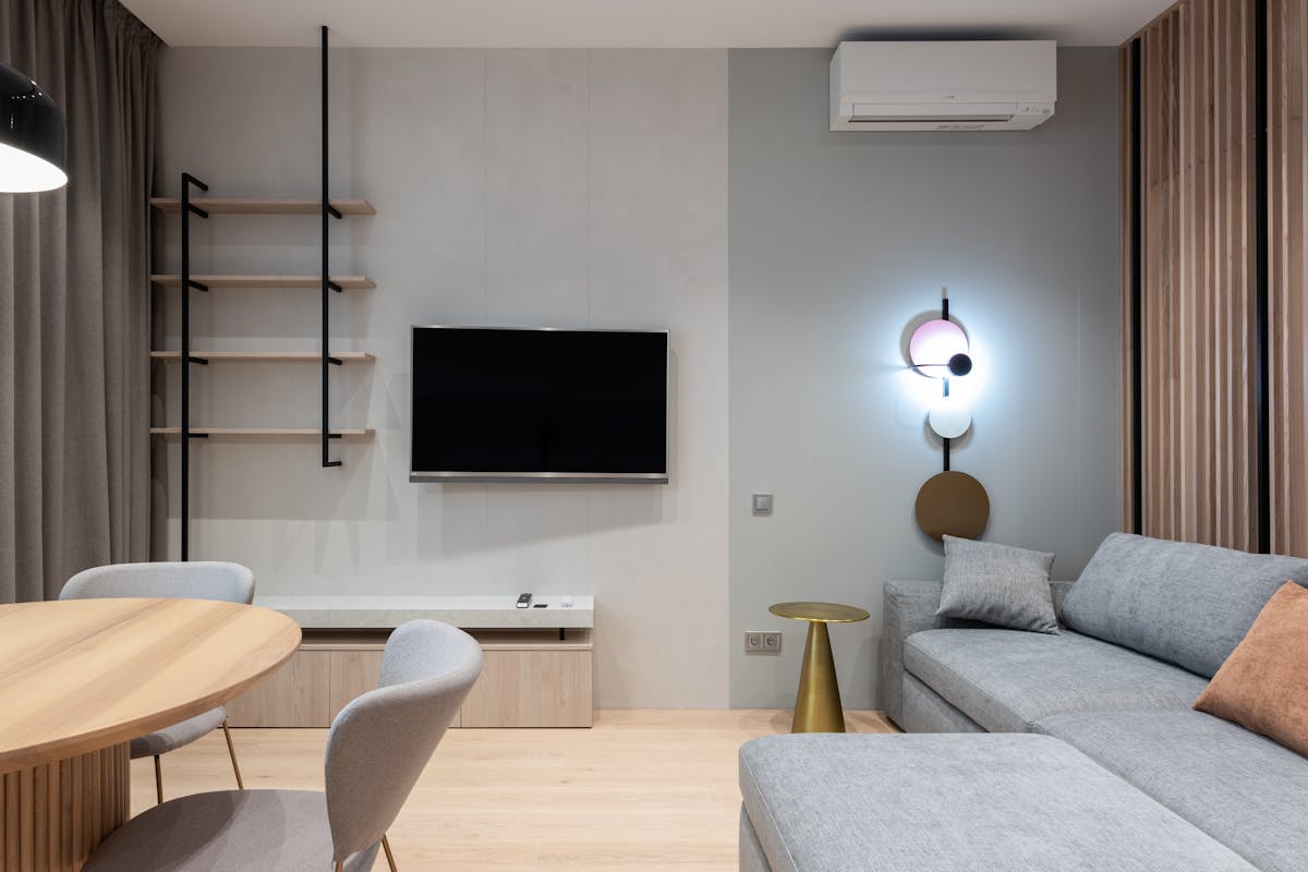 Compact living room with sofa, rug, wall shelves, and multifunctional furniture creating defined zones