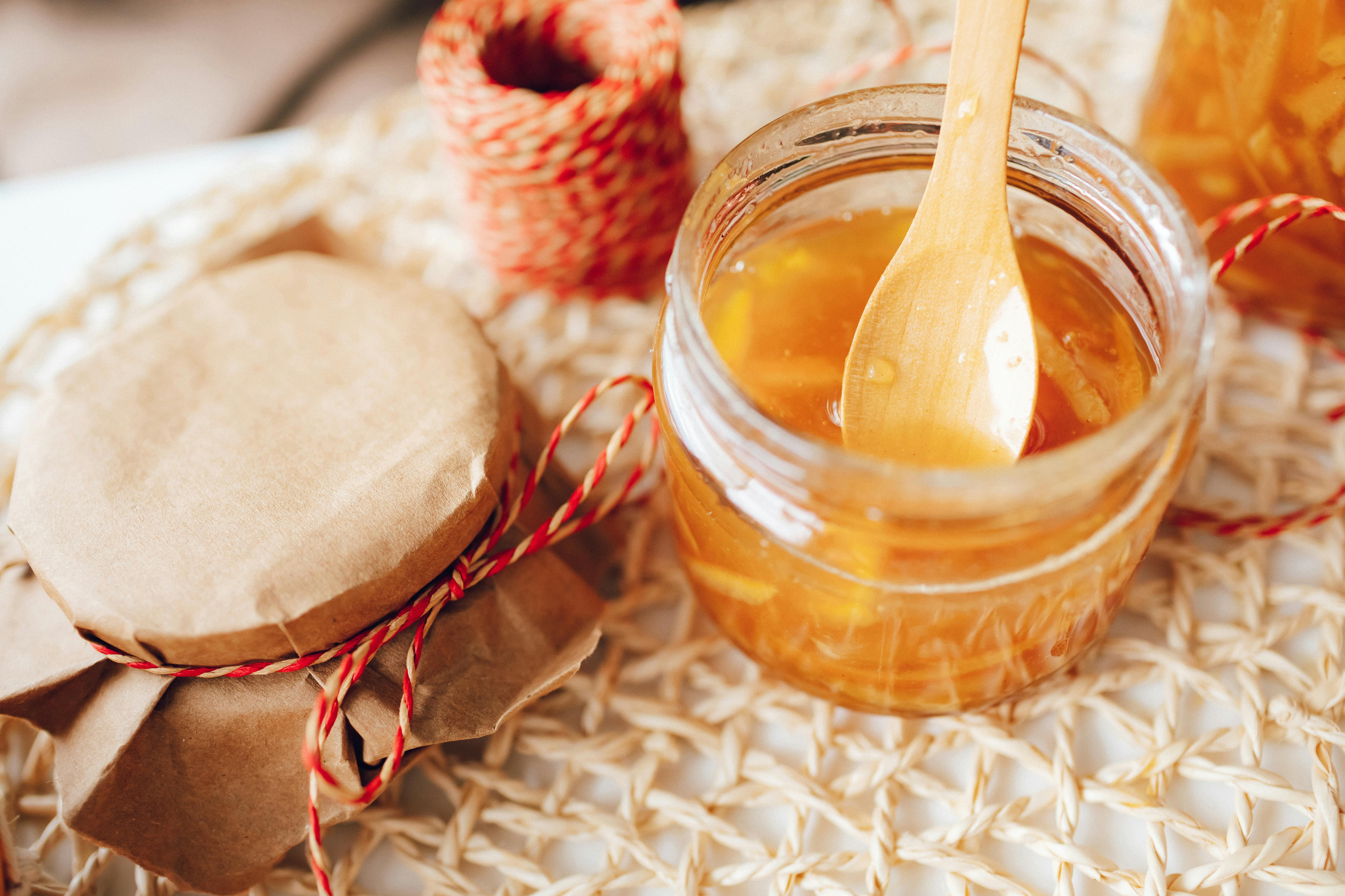 Delicious homemade citrus jam in a jar with a wooden spoon, perfect for breakfast spreads.